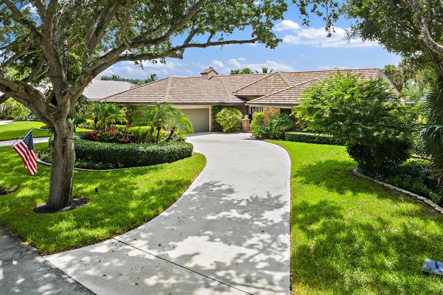 single story home featuring a garage and a front lawn