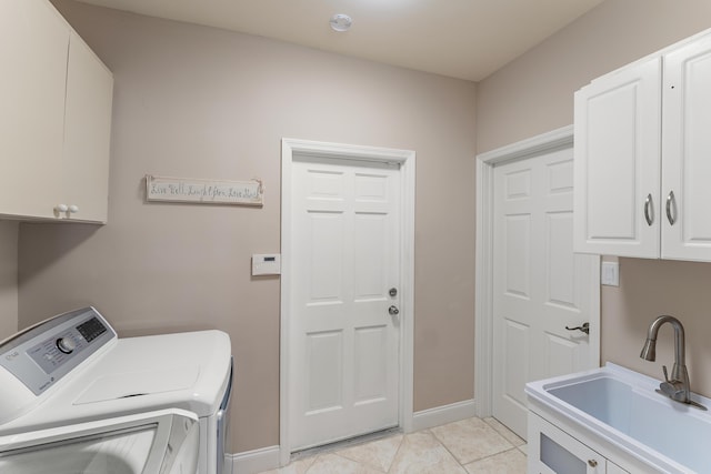 laundry room featuring cabinets, light tile patterned floors, sink, and washing machine and dryer