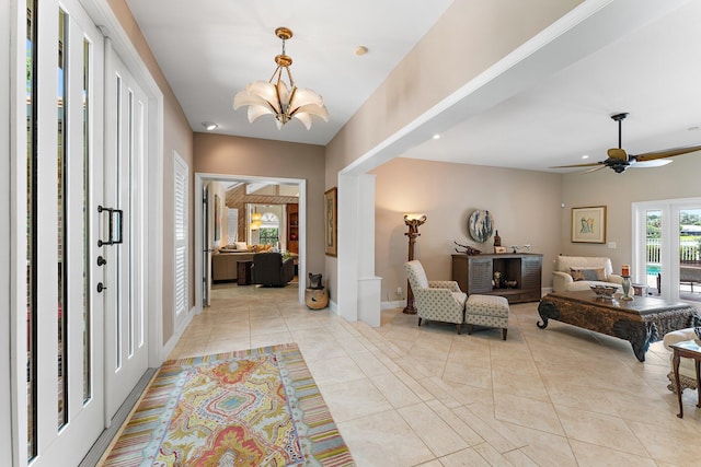 entrance foyer with light tile patterned floors and ceiling fan with notable chandelier