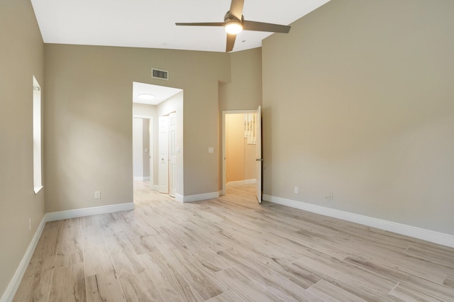 unfurnished bedroom featuring ceiling fan, light wood-type flooring, and high vaulted ceiling