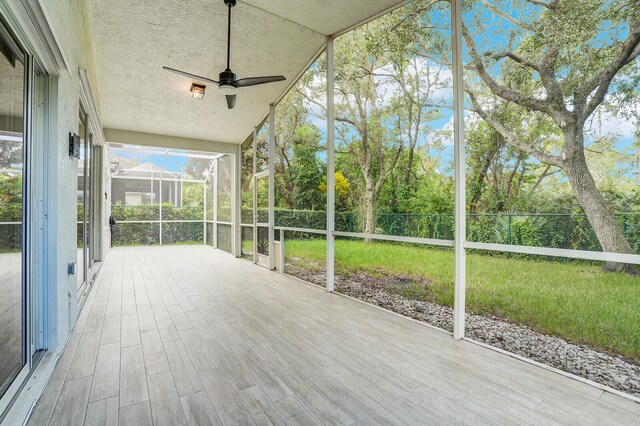 unfurnished sunroom featuring ceiling fan