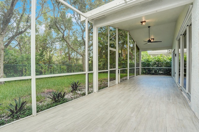 unfurnished sunroom featuring a healthy amount of sunlight, lofted ceiling, and ceiling fan