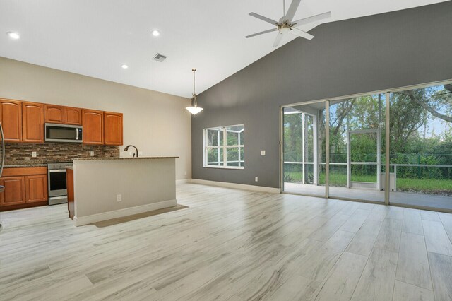 kitchen with appliances with stainless steel finishes, hanging light fixtures, high vaulted ceiling, light wood-type flooring, and ceiling fan