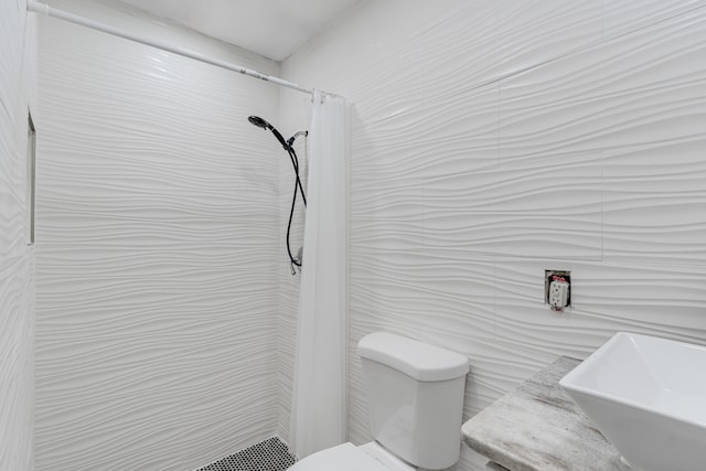 bathroom with tile walls, toilet, sink, and a shower with curtain