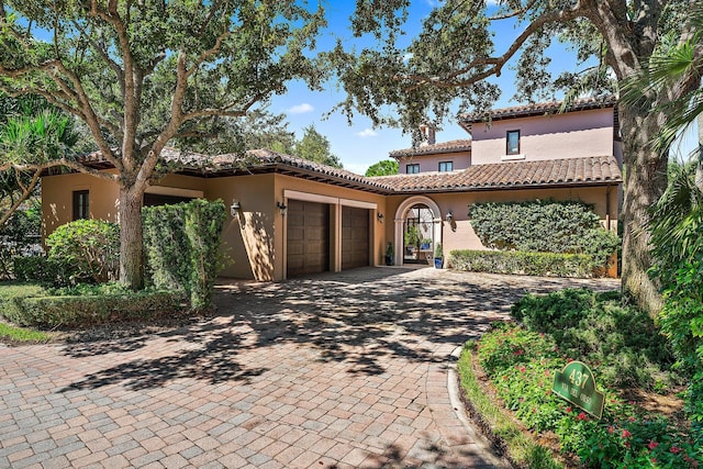 mediterranean / spanish home featuring a garage