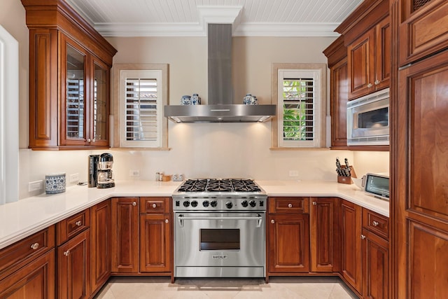 kitchen with light tile patterned flooring, appliances with stainless steel finishes, wall chimney exhaust hood, and crown molding