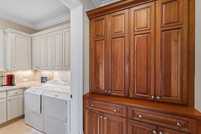 laundry area with cabinets, crown molding, and washing machine and dryer