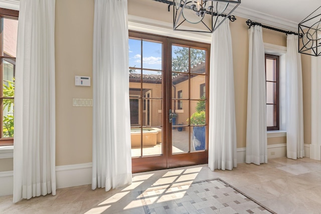 doorway to outside featuring ornamental molding, an inviting chandelier, and french doors