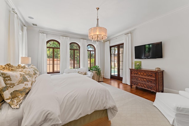 bedroom with crown molding, access to exterior, an inviting chandelier, and hardwood / wood-style flooring