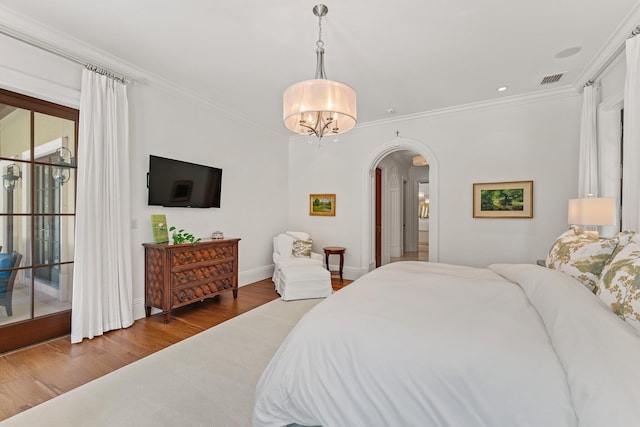 bedroom featuring a notable chandelier, wood-type flooring, access to outside, and crown molding