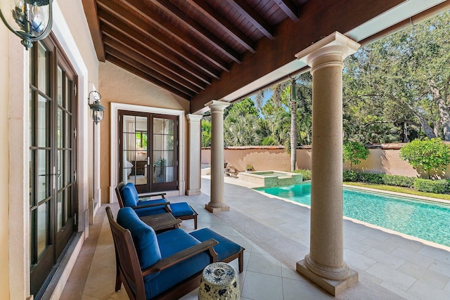 view of swimming pool featuring a patio, an in ground hot tub, and french doors