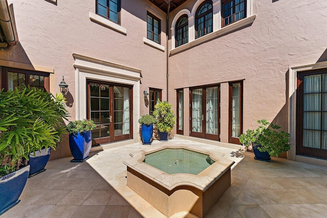 view of patio / terrace featuring french doors and an in ground hot tub