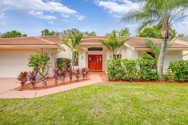 view of front of home featuring a front yard, french doors, and a garage