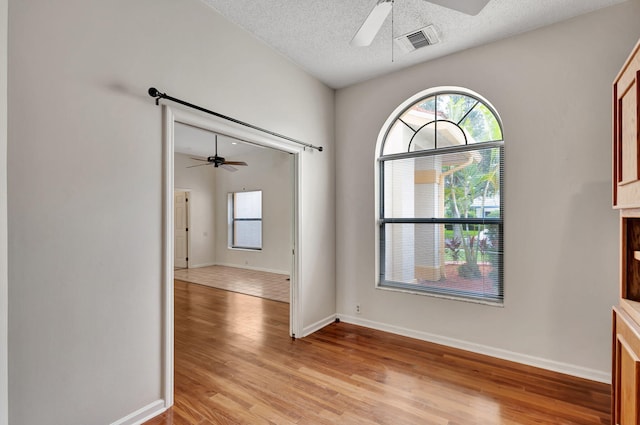 interior space featuring light hardwood / wood-style floors, ceiling fan, and a textured ceiling