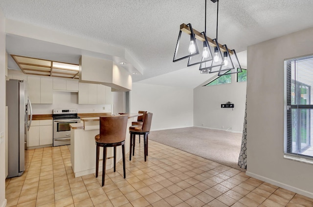 kitchen featuring a healthy amount of sunlight, white cabinetry, a breakfast bar area, and stainless steel appliances