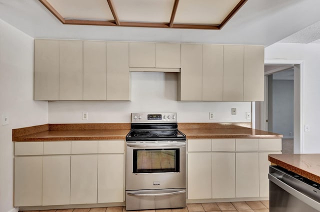 kitchen with cream cabinetry, light tile patterned flooring, and stainless steel appliances