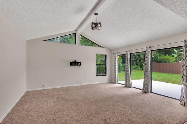 unfurnished living room with carpet floors, a textured ceiling, lofted ceiling with beams, and a healthy amount of sunlight