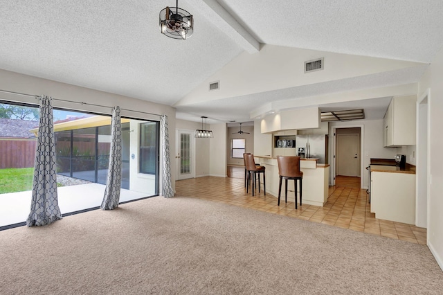 carpeted living room featuring vaulted ceiling with beams and a textured ceiling