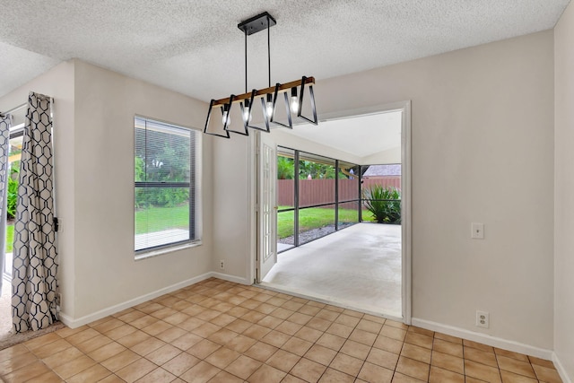 unfurnished dining area featuring a textured ceiling and light tile patterned floors