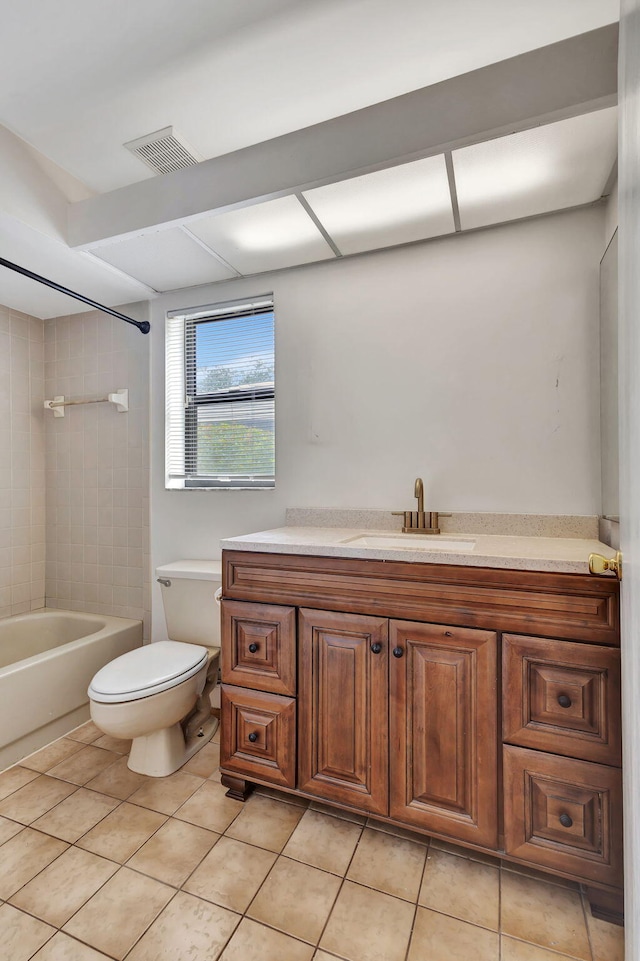 full bathroom with tile patterned floors, tiled shower / bath combo, vanity, and toilet