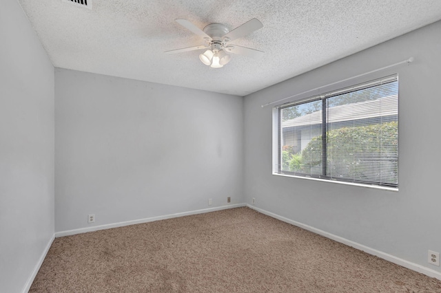 spare room with a textured ceiling, carpet flooring, and ceiling fan