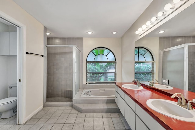 full bathroom with vanity, toilet, plus walk in shower, and tile patterned floors