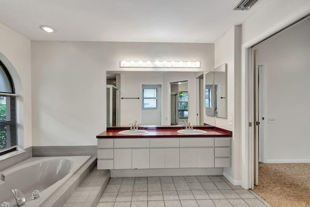 bathroom featuring tile patterned flooring, independent shower and bath, and vanity