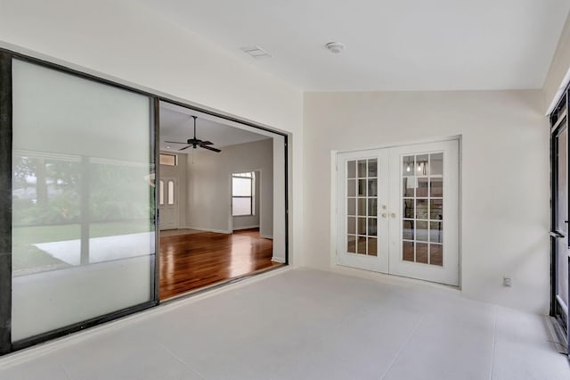 unfurnished room with light tile patterned floors, lofted ceiling, ceiling fan, and french doors