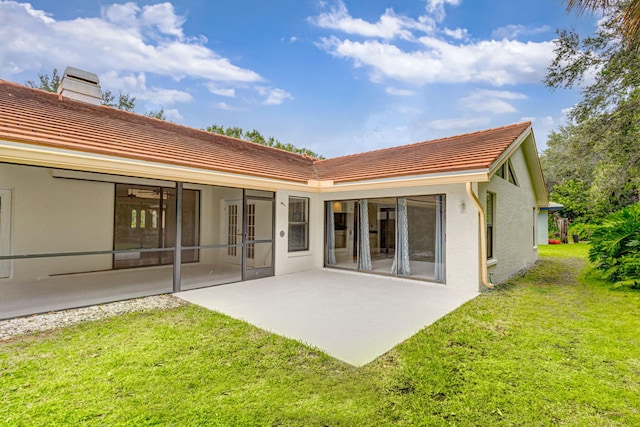 rear view of property with a lawn and a patio