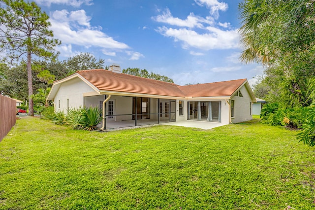 back of property with a lawn and a patio