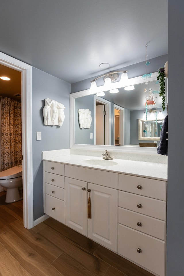 bathroom with hardwood / wood-style floors, vanity, and toilet