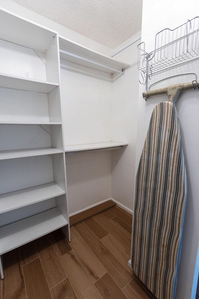 spacious closet featuring dark hardwood / wood-style flooring