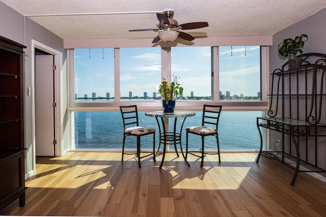 dining space featuring light hardwood / wood-style floors, ceiling fan, and a textured ceiling