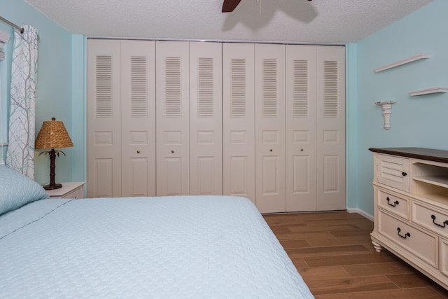 bedroom featuring a textured ceiling, dark wood-type flooring, and a closet