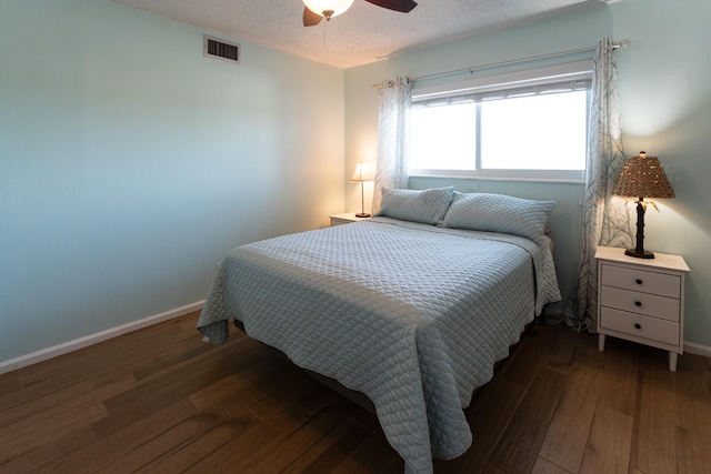 bedroom featuring ceiling fan, a textured ceiling, and dark wood-type flooring