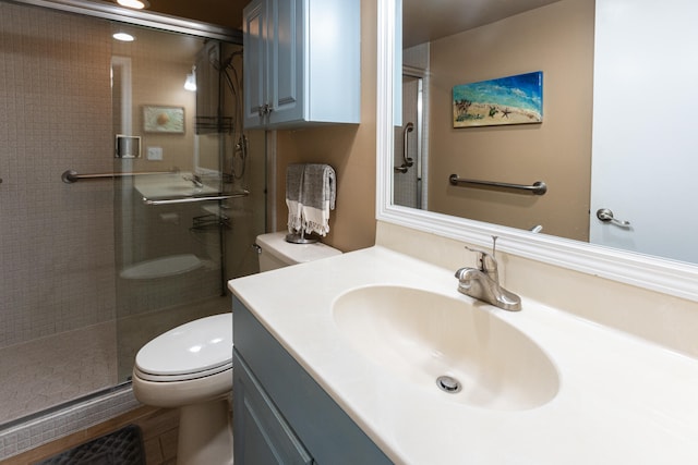 bathroom with vanity, toilet, and a shower with door