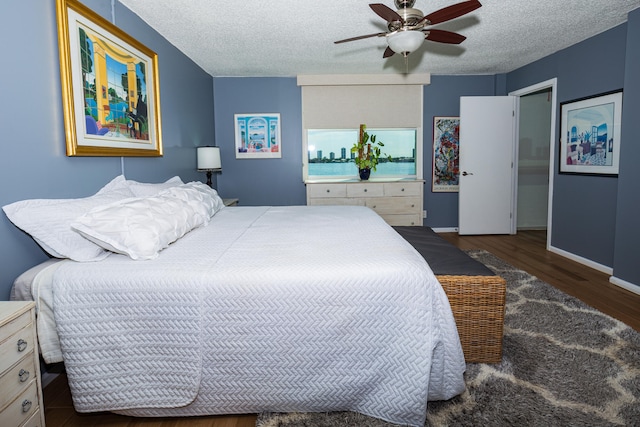 bedroom with a textured ceiling, dark hardwood / wood-style floors, and ceiling fan