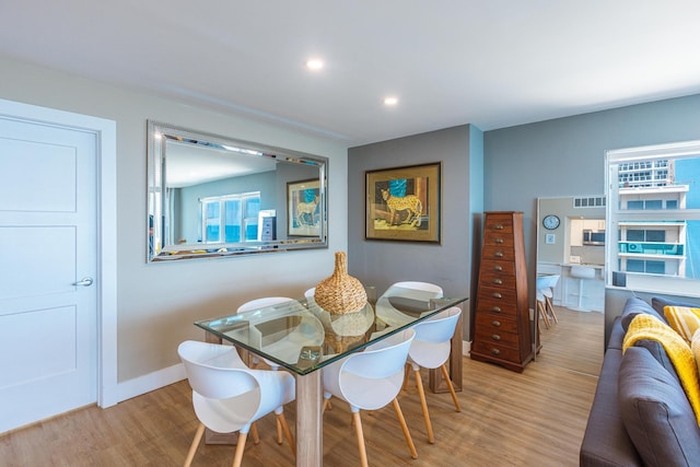 dining space with light hardwood / wood-style floors and a healthy amount of sunlight