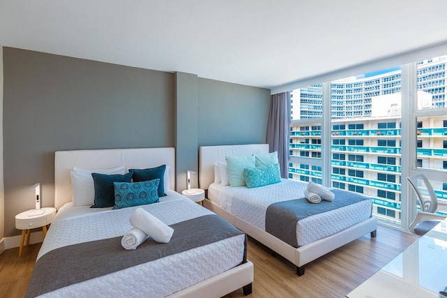 bedroom featuring expansive windows and wood-type flooring