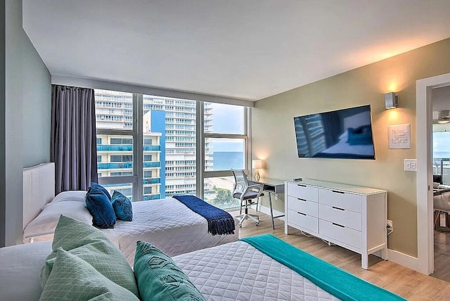 bedroom with light hardwood / wood-style flooring and a wall of windows