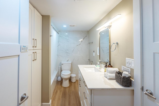 bathroom featuring a shower, hardwood / wood-style floors, vanity, and toilet