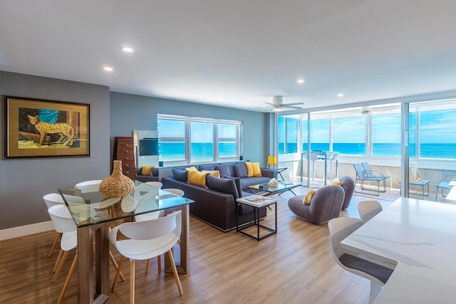 living room with a water view, ceiling fan, and light hardwood / wood-style floors