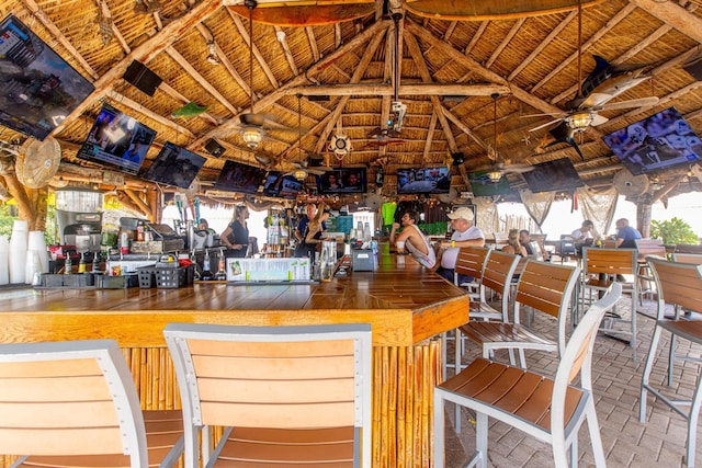 bar with vaulted ceiling and ceiling fan