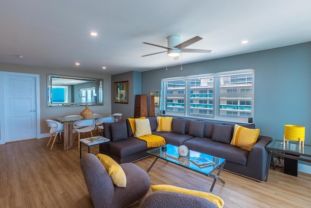 living room featuring a wealth of natural light, ceiling fan, and light hardwood / wood-style floors