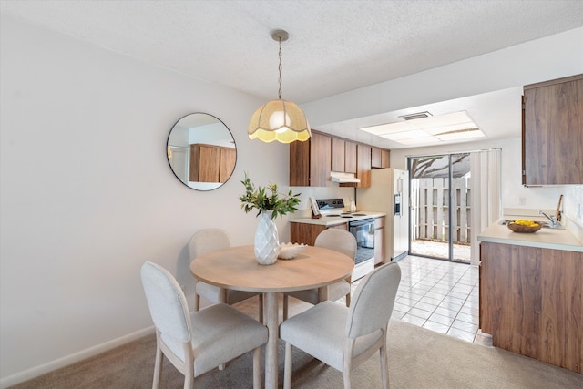 carpeted dining area featuring sink and a textured ceiling