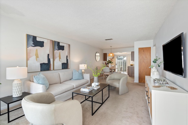 carpeted living room featuring a textured ceiling