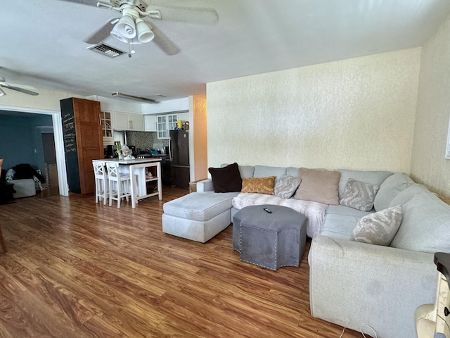 living room featuring hardwood / wood-style flooring and ceiling fan