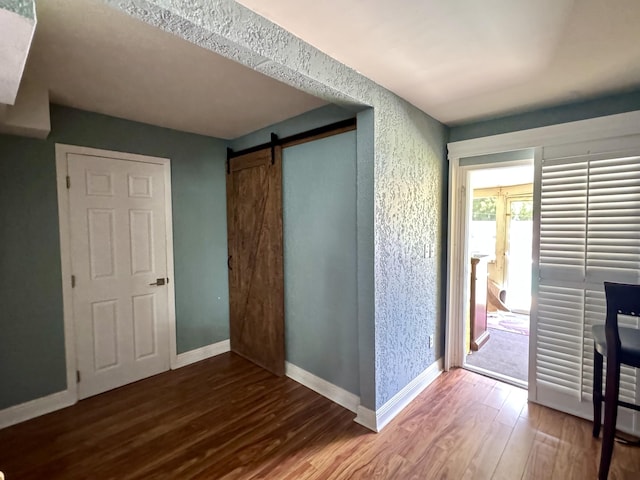 corridor featuring hardwood / wood-style flooring and a barn door