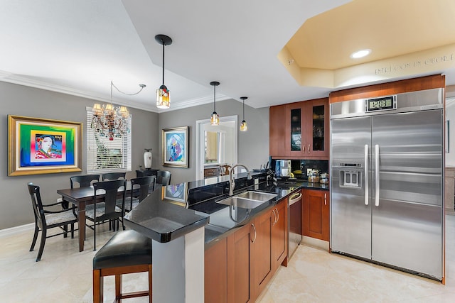 kitchen with brown cabinetry, a sink, stainless steel appliances, glass insert cabinets, and dark countertops