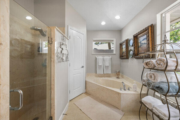 bathroom featuring independent shower and bath, tile patterned floors, and a wealth of natural light